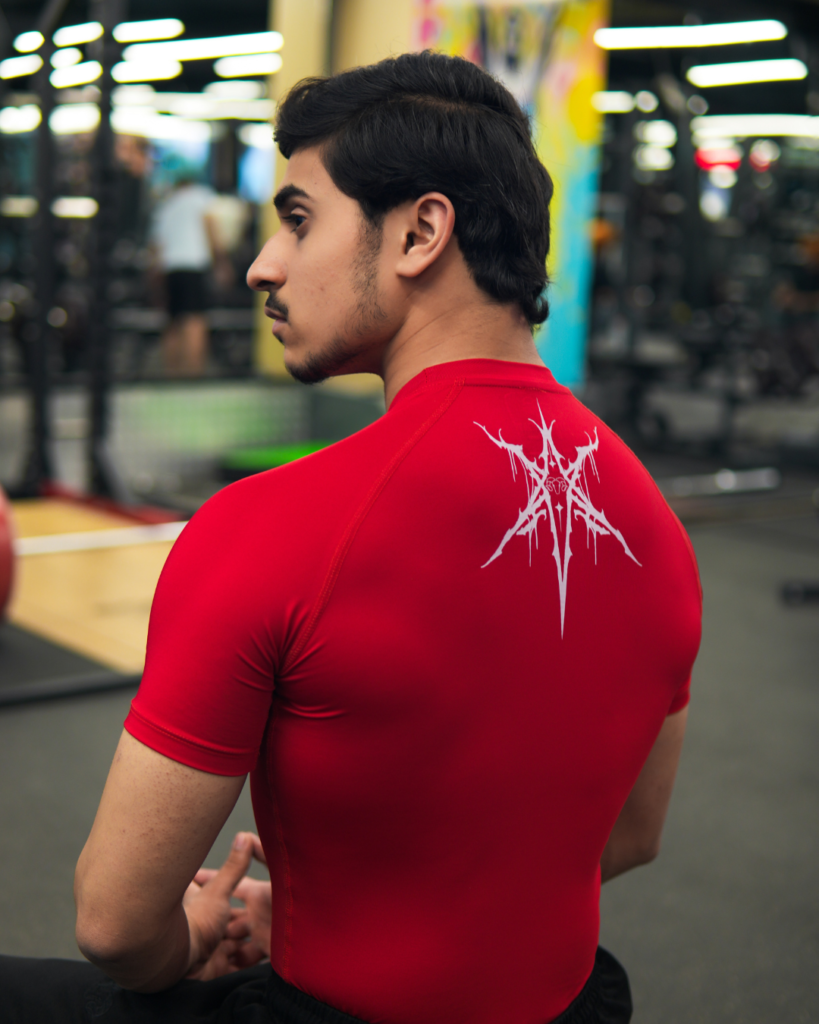 Young Goat red compression t-shirt back graphic seated in gym — men's compression wear India