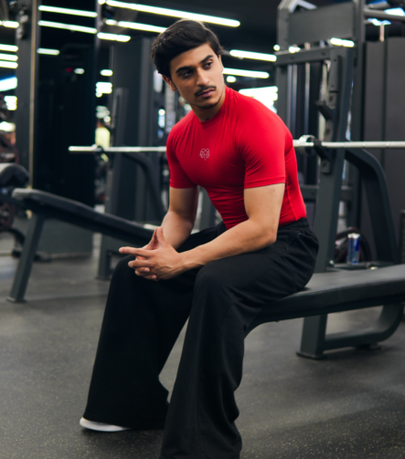 Young Goat red compression t-shirt full lifestyle gym shot — men seated India