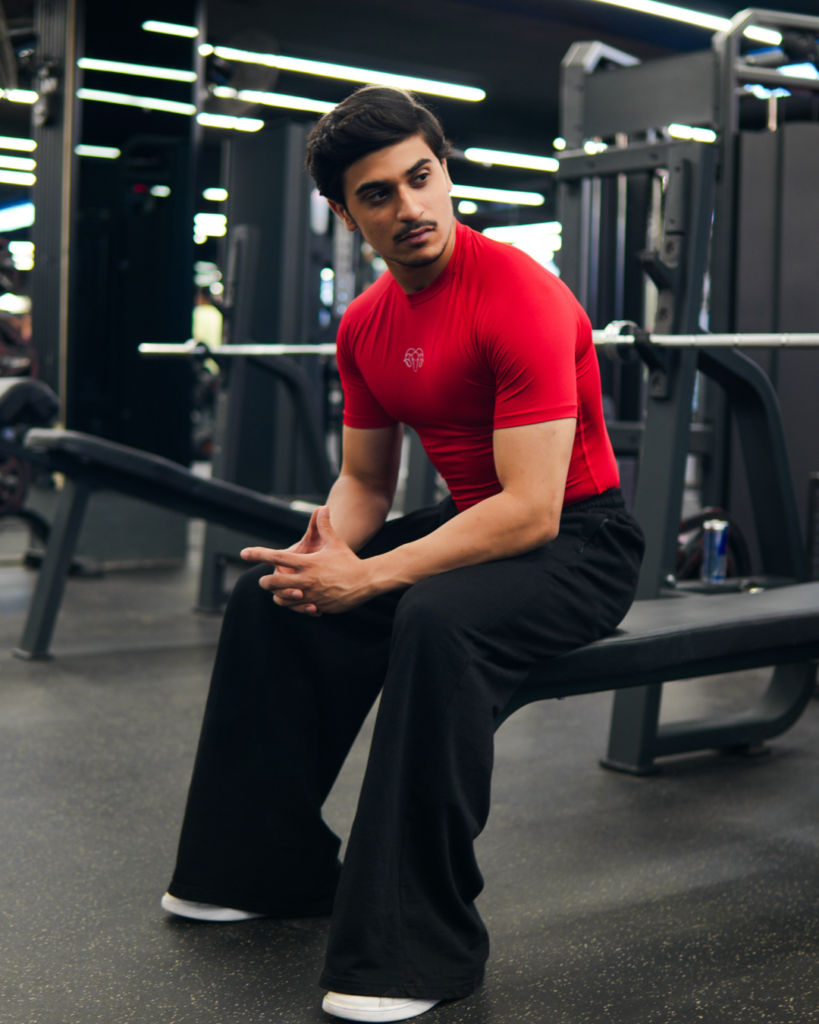 Young Goat red compression t-shirt full lifestyle gym shot — men seated India